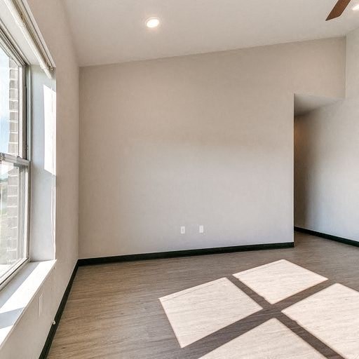 an empty room with a large window and a rug
