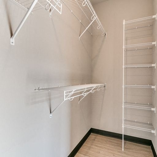 a walk in closet with empty shelves on the wall
