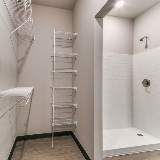 a white bathroom with a shower and a ladder on the wall
