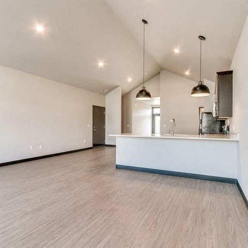 an empty kitchen and living room with a counter top