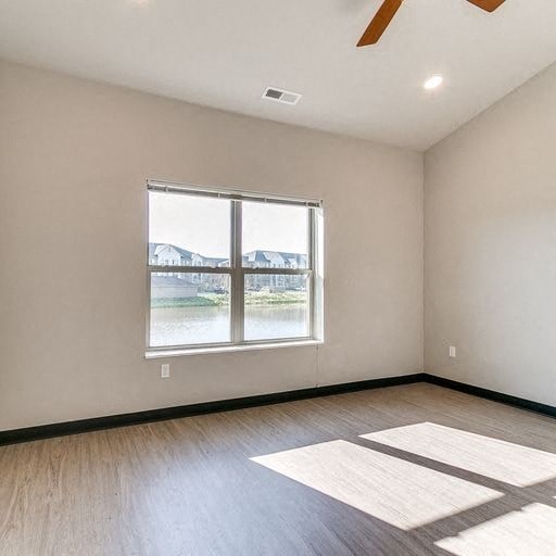 an empty room with a large window and wooden floors