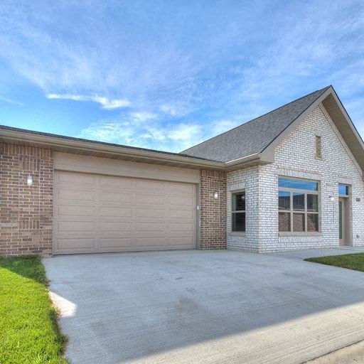 a brick house with a driveway and a garage door