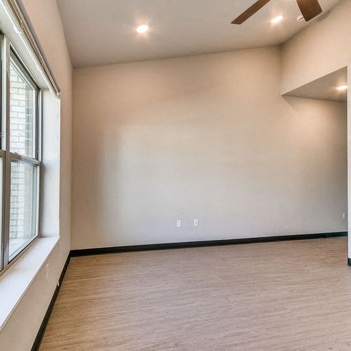 a living room with a large white wall and a window