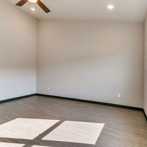 an empty room with wood floors and a white wall