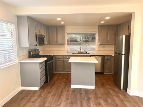 A kitchen with wooden floors and white appliances.