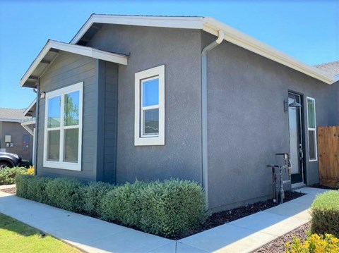 a gray house with a sidewalk in front of it
