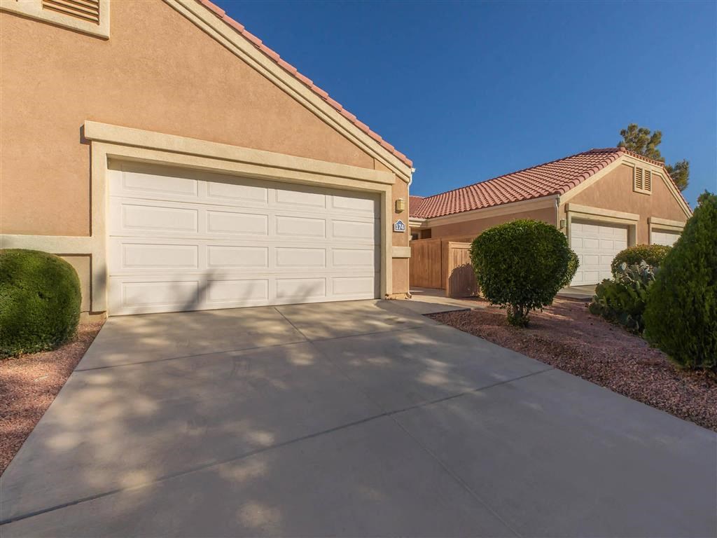 a white garage door on a driveway in front of a house
