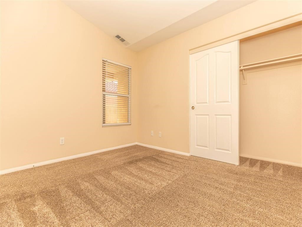 a room with carpet and a door to a closet