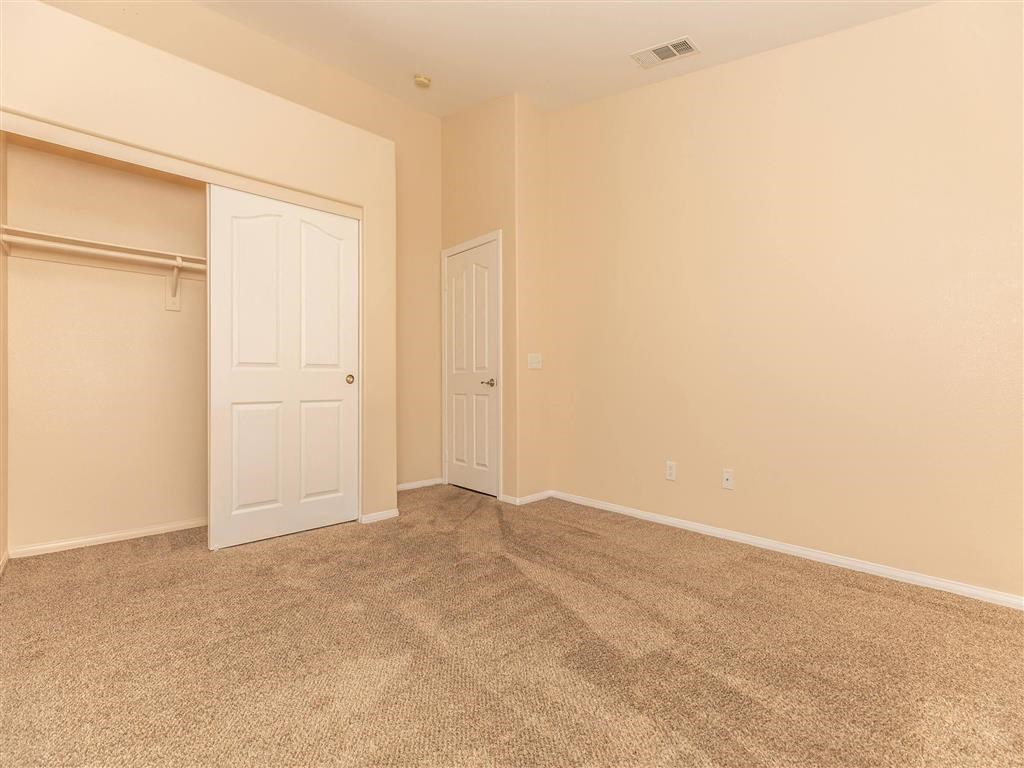 an empty living room with a closet and a door
