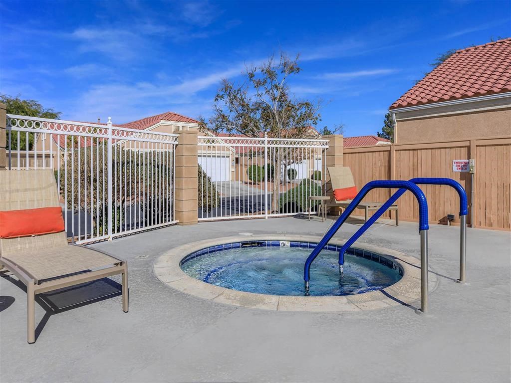 a small pool with a blue slide in a yard with a fence