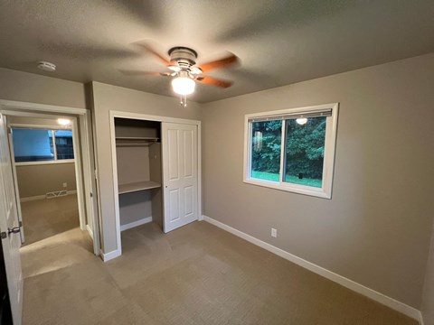 A room with a ceiling fan and a window.