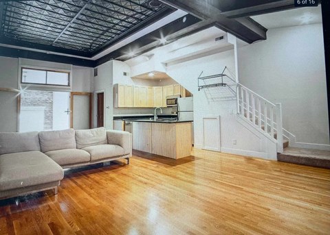 an empty living room with a couch and a kitchen