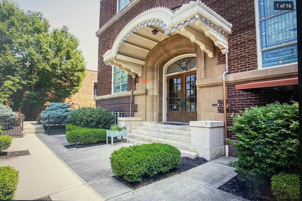 the front of a brick building with stairs and a door