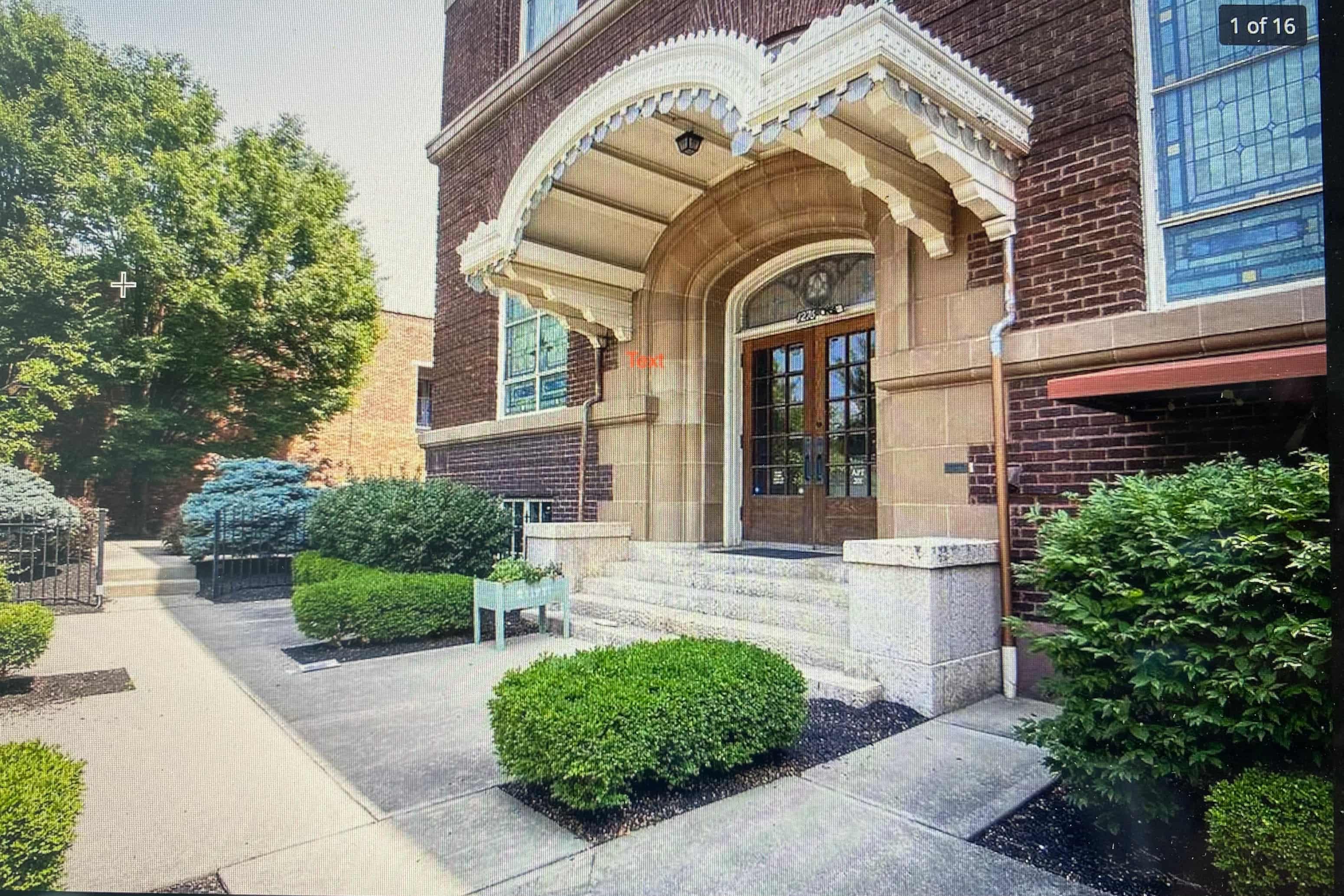 the front of a brick building with stairs and a door