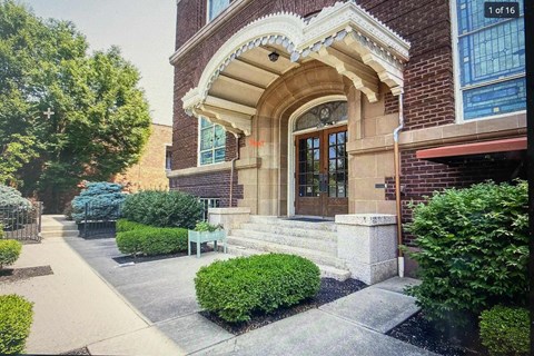the front of a brick building with stairs and a door