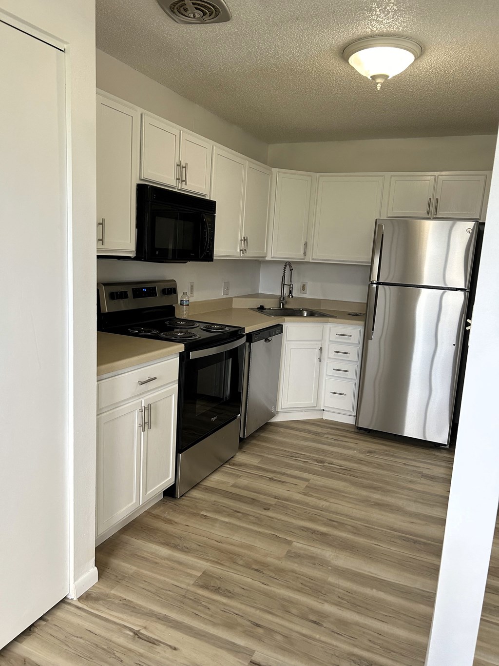 a kitchen with white cabinets and stainless steel appliances