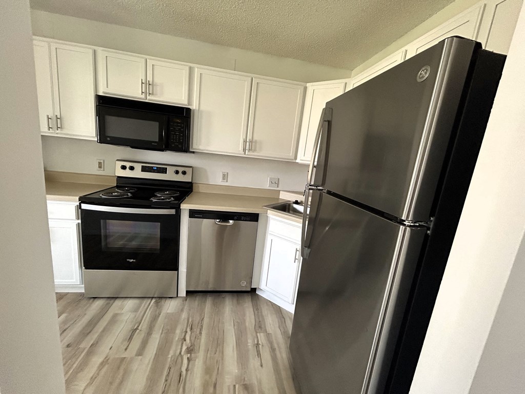 a kitchen with stainless steel appliances and white cabinets