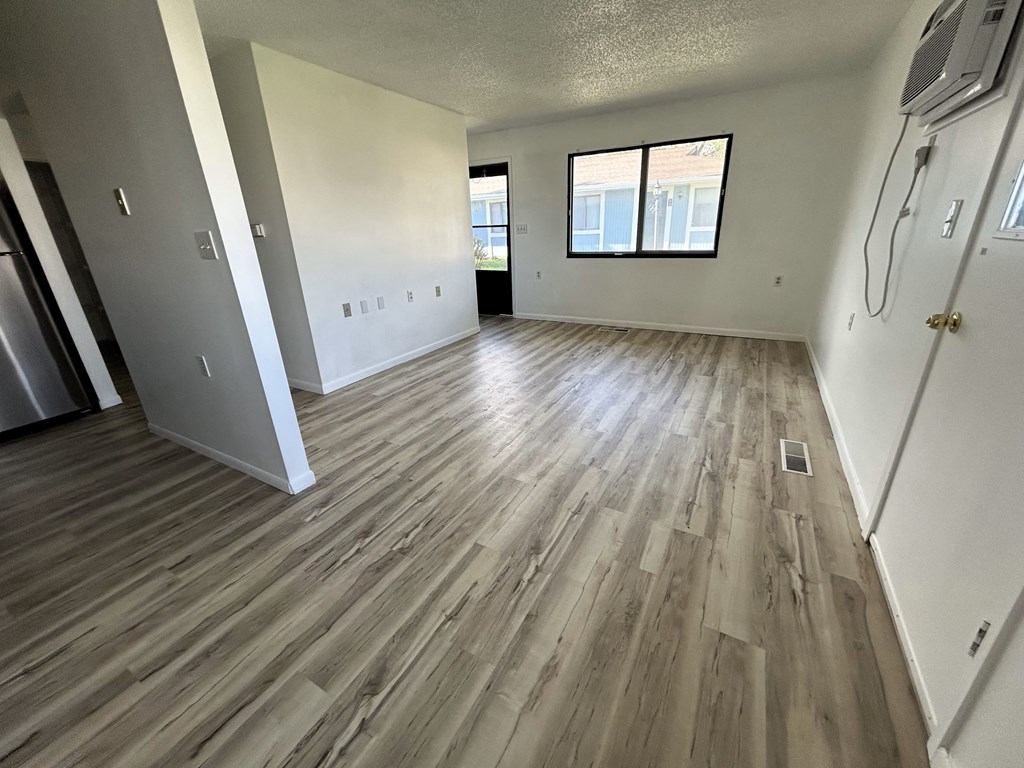 the living room of an empty apartment with wood flooring