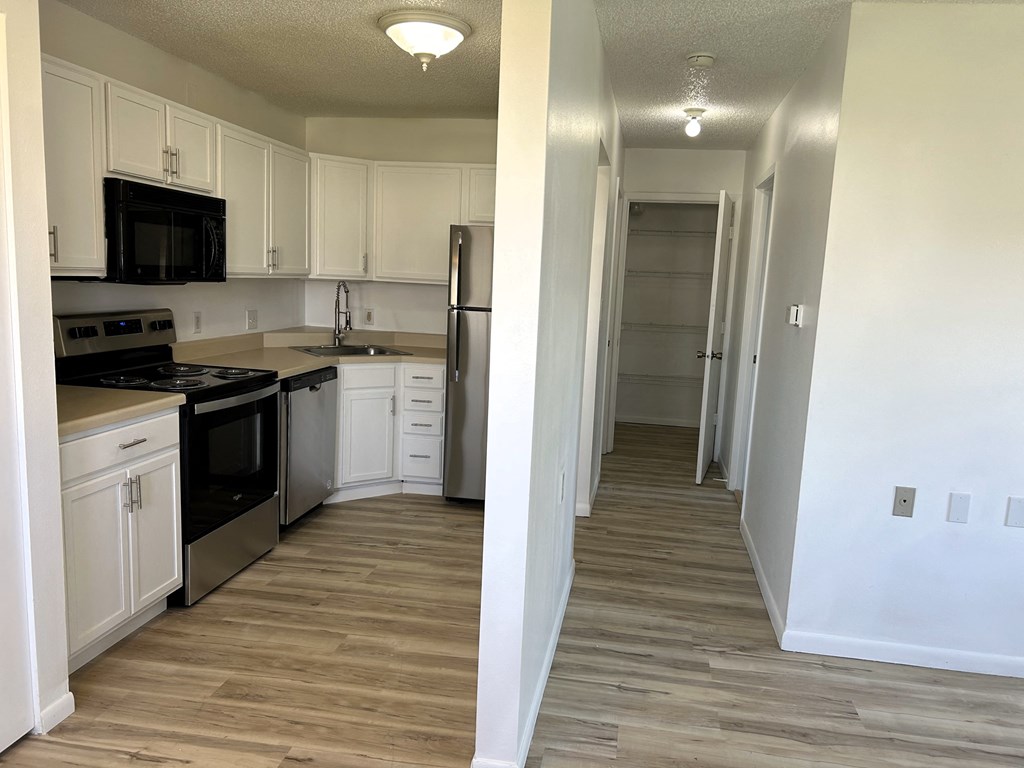 a renovated kitchen with white cabinets and black appliances