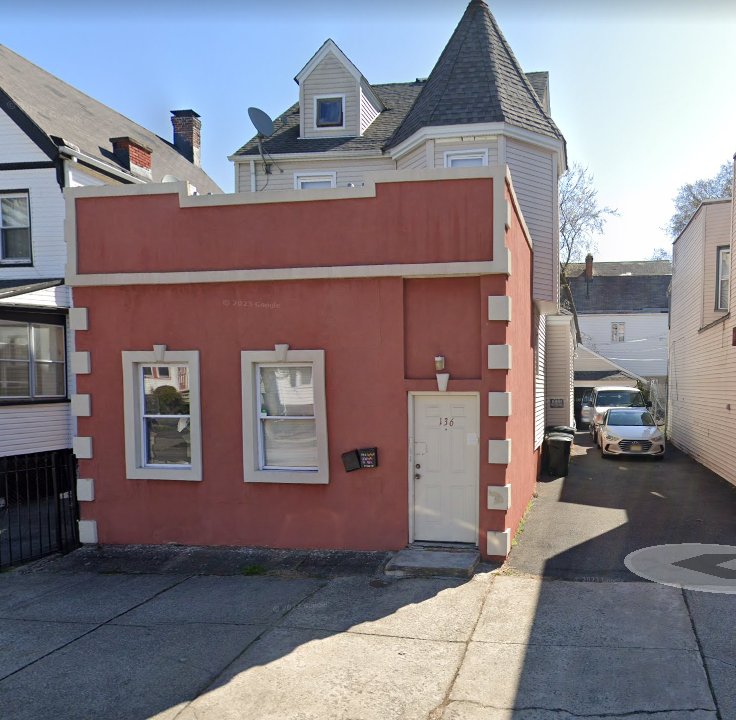 a red building with a white house on top of it