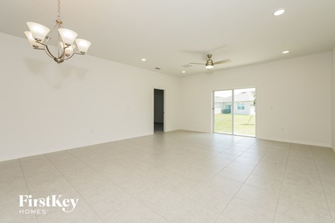 A spacious room with a chandelier and a ceiling fan.