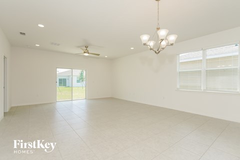 A spacious room with a chandelier and a ceiling fan.