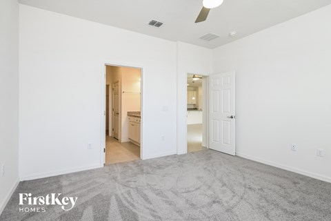 a living room with a carpeted floor and a door to a bathroom
