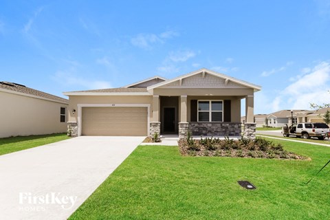 a house with a driveway and lawn in front of it