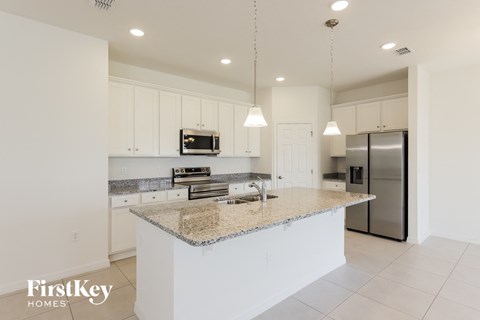 a kitchen with white cabinets and a granite counter top