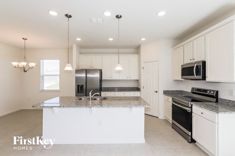 a kitchen with white cabinets and granite counter tops