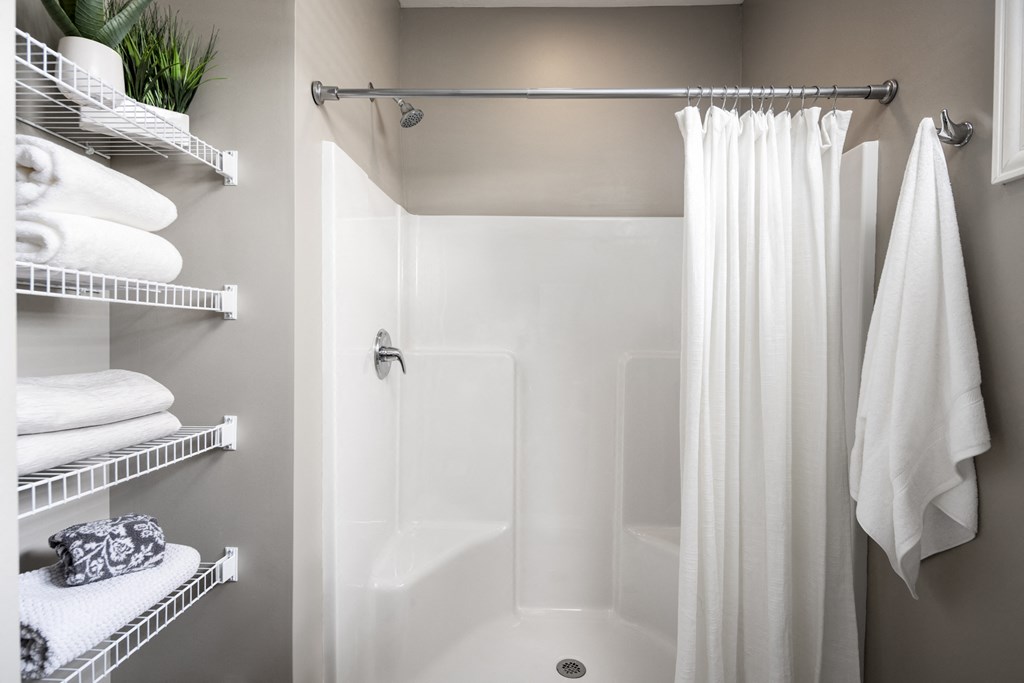 a small bathroom with a shower and white towels