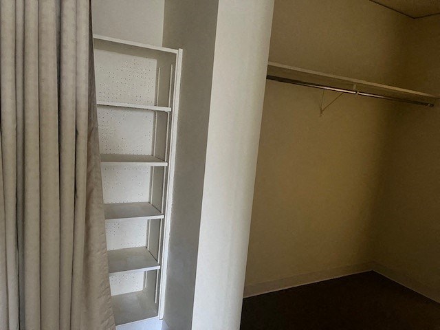 an empty closet with shelves and a curtain