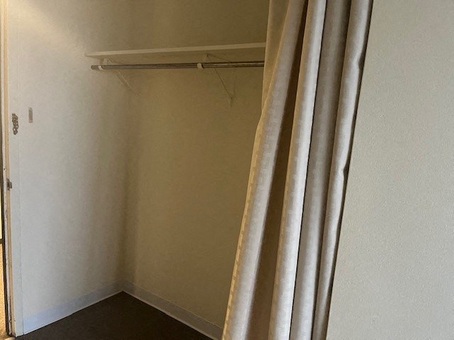 a small room with a shower curtain and a white wall