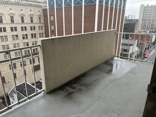 a balcony with a concrete wall on top of a building