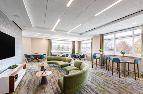 a room with couches chairs and tables and a television