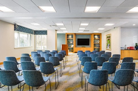 a conference room with rows of chairs and a television