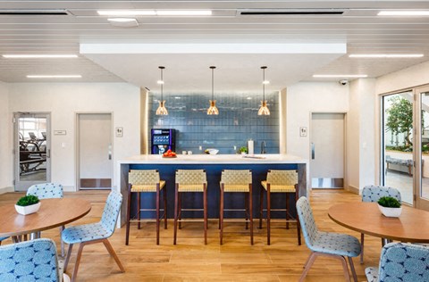 a large kitchen with blue chairs and a bar with a blue counter top
