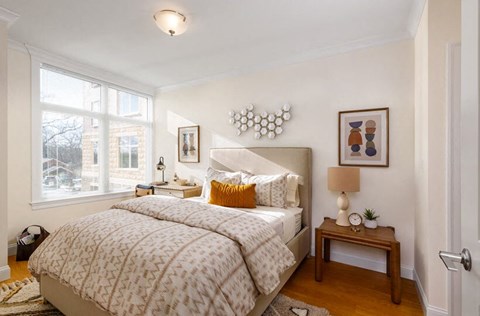 A bedroom with a large bed and a window.
