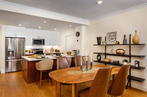 A modern kitchen with a wooden table and chairs.