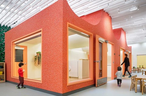 A red building with children playing in front of it.