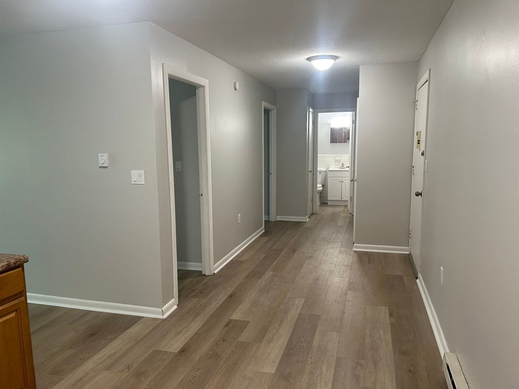 a renovated living room and hallway with wood floors and grey walls