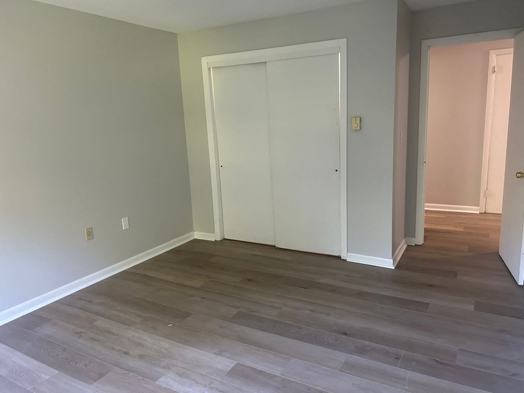 a room with a hard wood floor and two closet doors