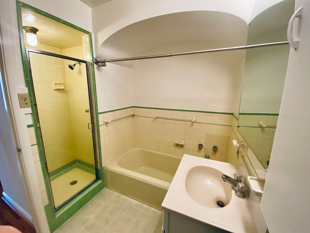 a bathroom with a sink and a tub and a shower