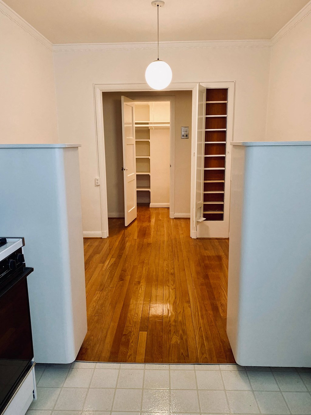 a view of a kitchen and a closet with a wood floor