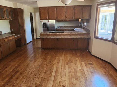 A kitchen with wooden floors and cabinets.