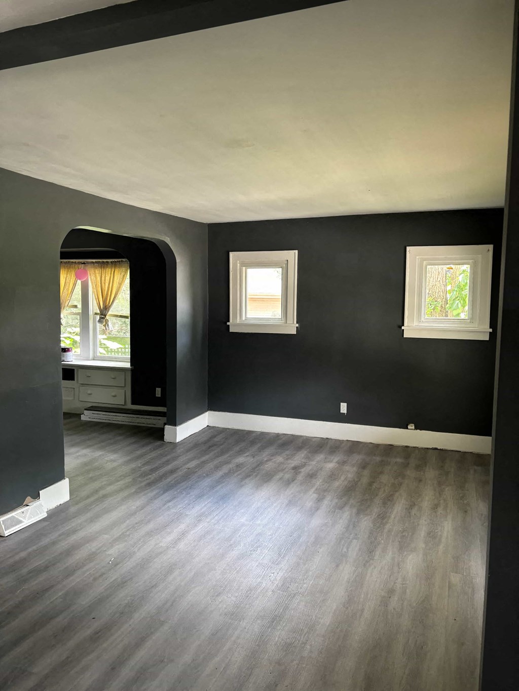 a living room with black walls and a wooden floor