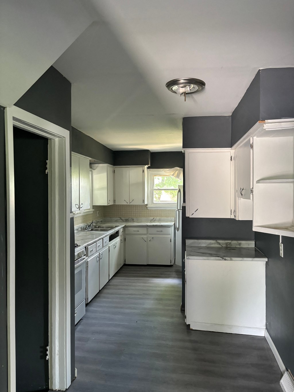 a kitchen with black and white cabinets and white appliances