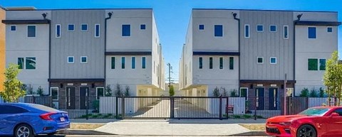 a row of apartment buildings with cars parked in front of them