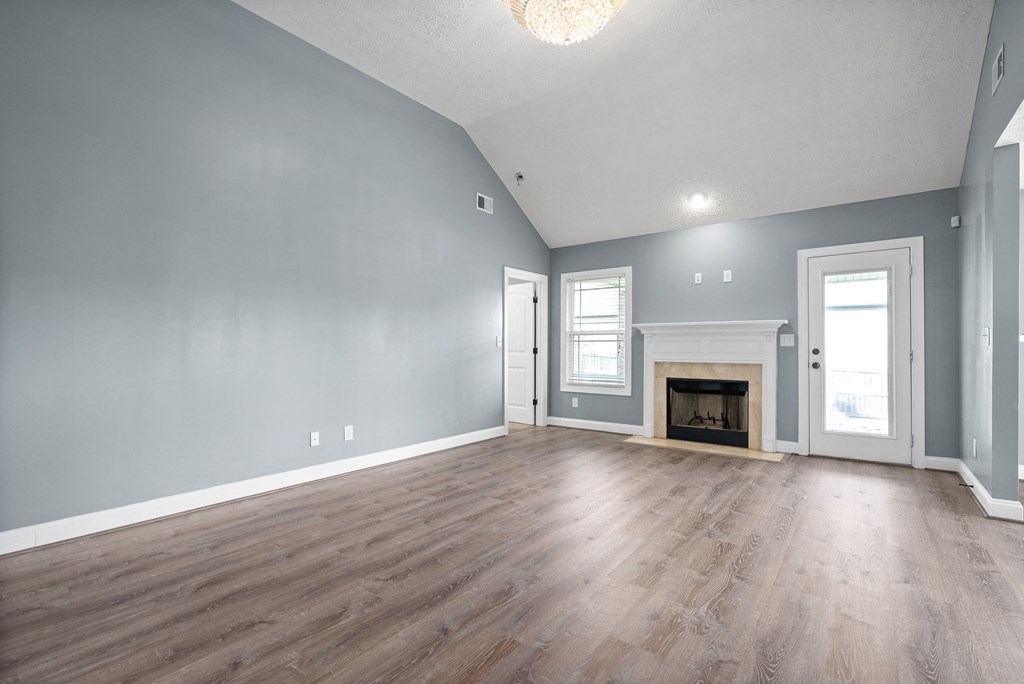 the living room of a new home with blue walls and a fireplace