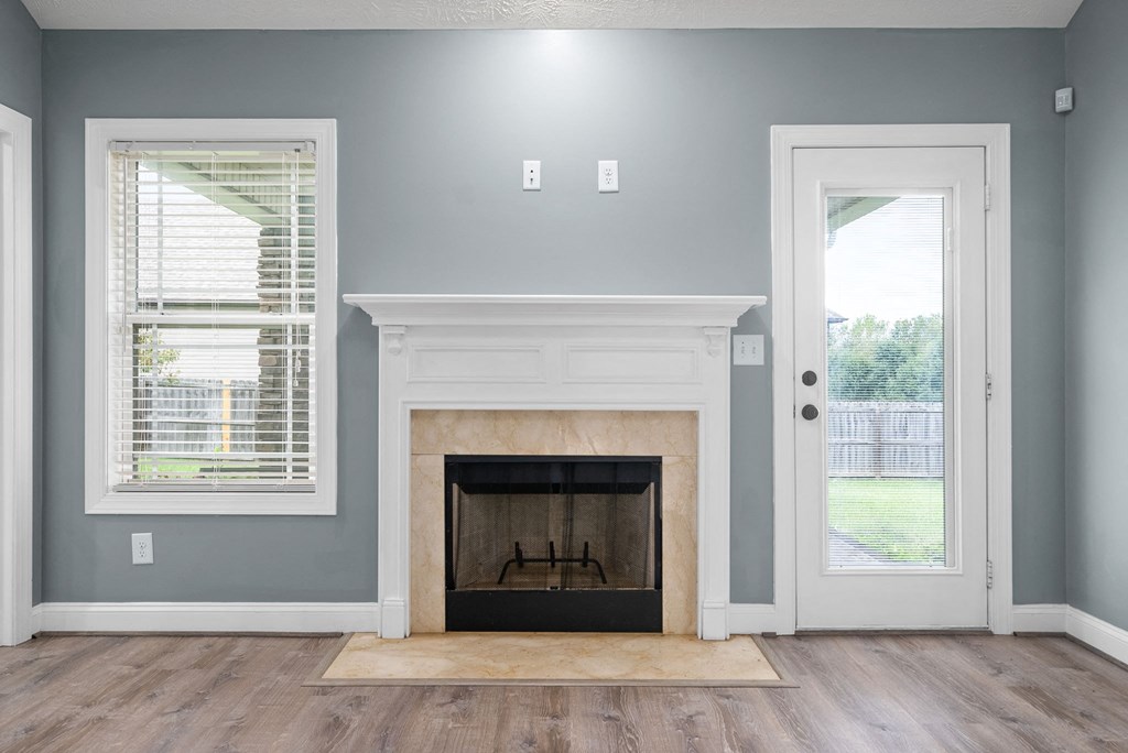 the living room has a fireplace and a door to the backyard